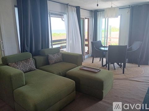 A living room with a sofa set and a dining table.