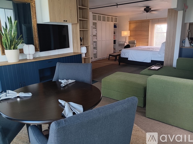 A room with a bed, a table, and a television.