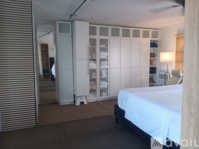 A bedroom with a bed, a wardrobe, and a chair.