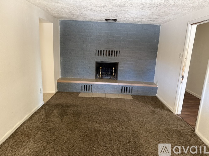 A living room with a fireplace and a carpeted floor.