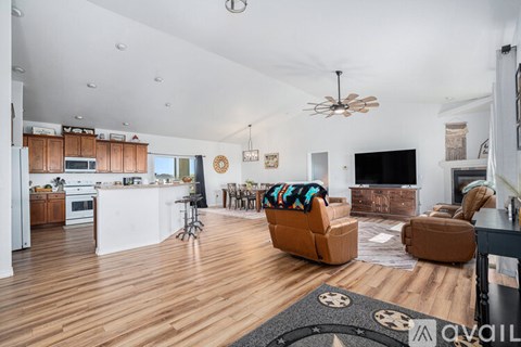 A living room with a brown leather couch and a wooden floor.
