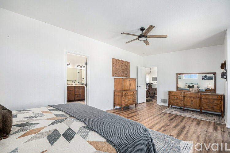 A bedroom with a large bed and a wooden dresser.