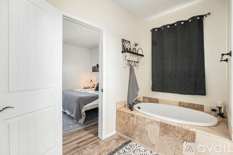 A bathroom with a tub and a bed in a small space.