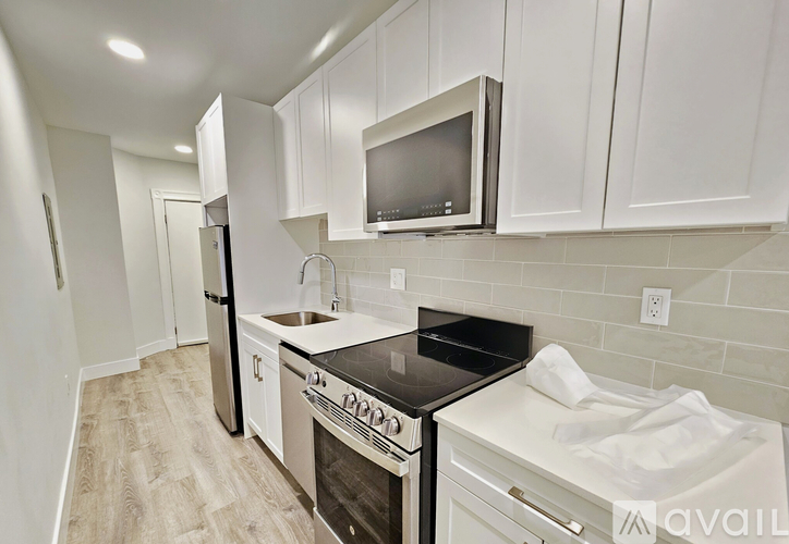 A kitchen with white cabinets and a black stove top.