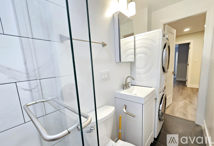 A bathroom with a glass shower door and a white toilet.