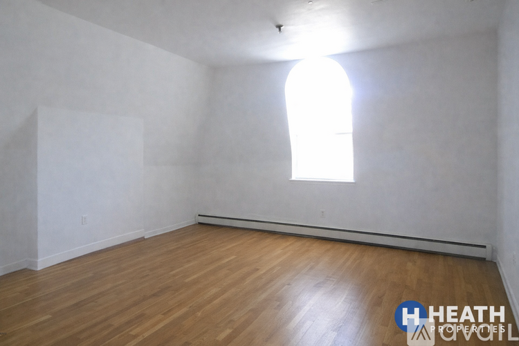 A room with wooden flooring and a window.