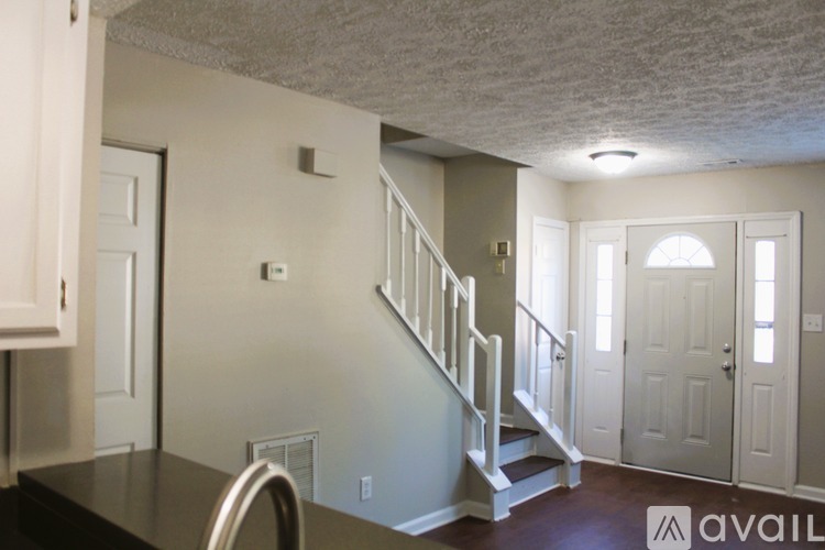 A kitchen with a staircase leading to the second floor.