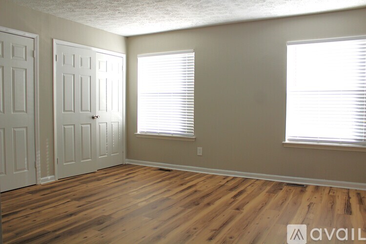 A room with wooden floors and two doors.