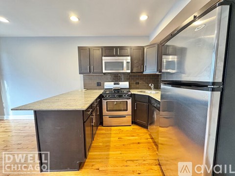 A kitchen with a stove top oven and a refrigerator.