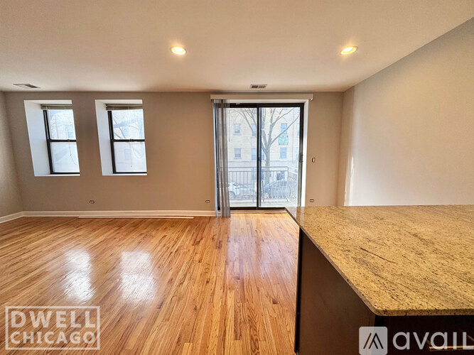 A spacious room with wooden floors and a large window.