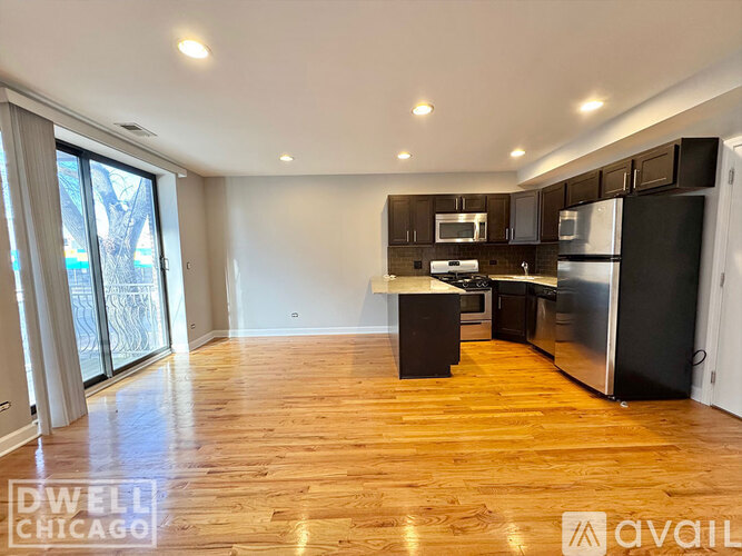 A kitchen with wooden floors and black appliances.