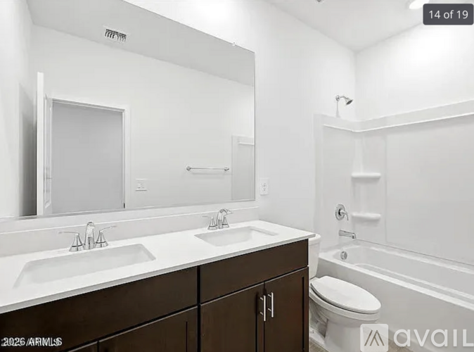 A bathroom with a white sink and brown cabinetry.