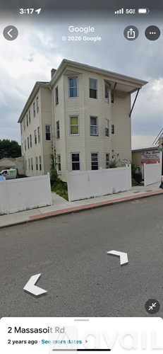 A white building with a red line on the sidewalk in front of it.