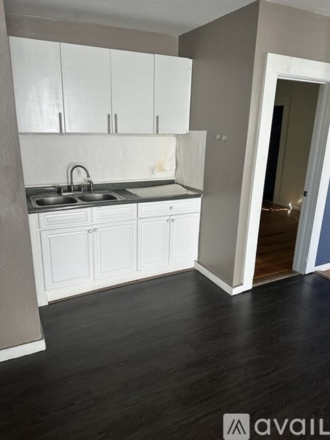 A kitchen with white cabinets and a sink.