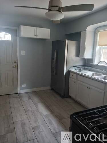 A kitchen with a black stove top oven and a white fridge.