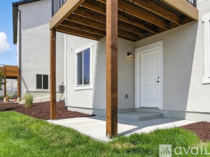 A modern house with a white door and a wooden pergola.