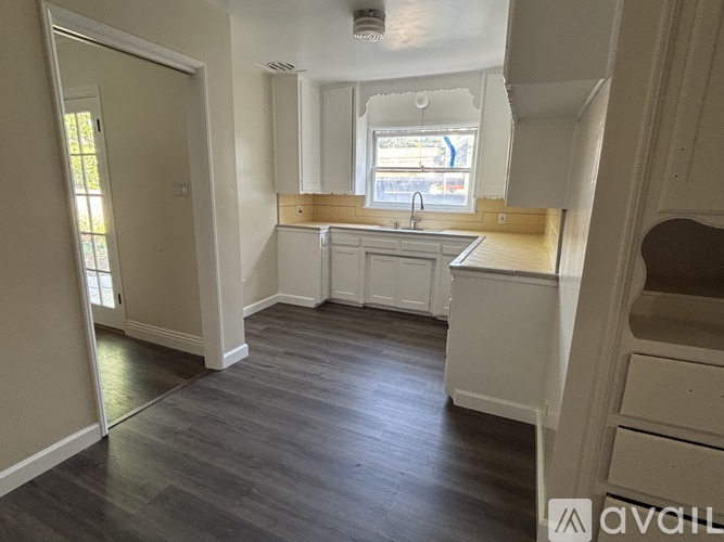 A kitchen with white cabinets and a window.