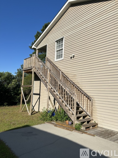 A house with a wooden staircase leading to a balcony.