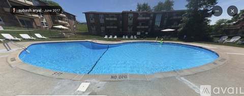 A large blue swimming pool in front of a building.