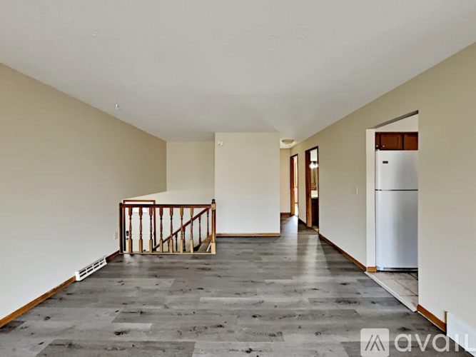 A room with a grey floor and a white ceiling with a wooden frame in the middle of the room.