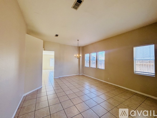 A spacious room with tiled flooring and a large window.