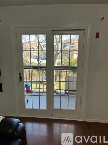 A white door with a glass window and a black leather chair in front of it.