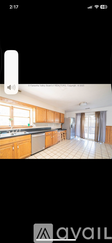 A kitchen with wooden cabinets and a tiled floor.