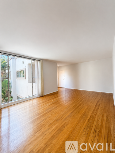 A room with wooden floors and a large window.