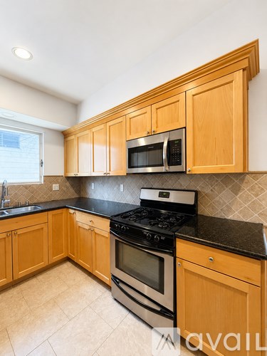 A kitchen with wooden cabinets and black countertops.