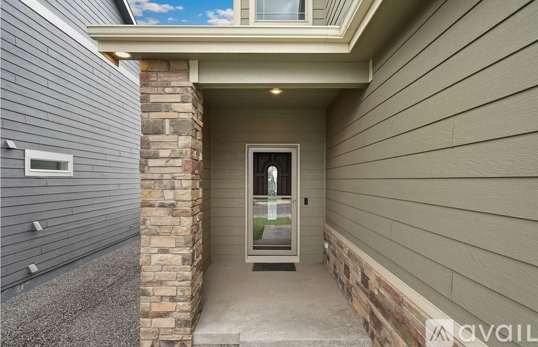 A house entrance with a glass door and a stone pillar.