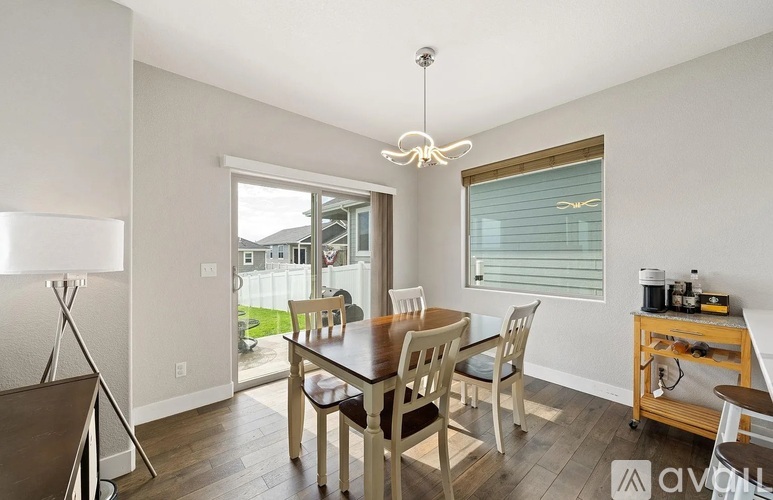 A dining room with a wooden table and chairs.
