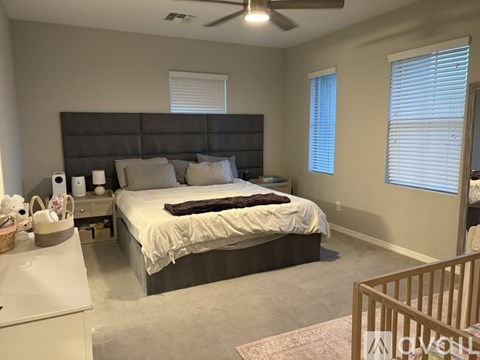 A bedroom with a large bed and a ceiling fan.