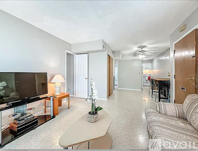A living room with a flat screen TV, a couch, and a coffee table.