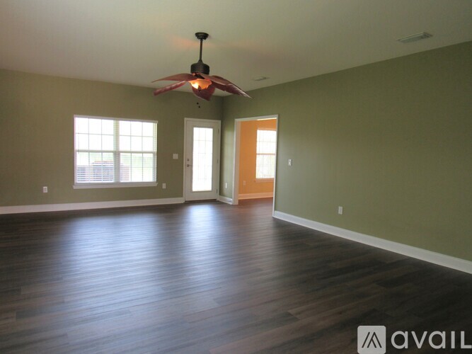 A room with a ceiling fan and wooden flooring.