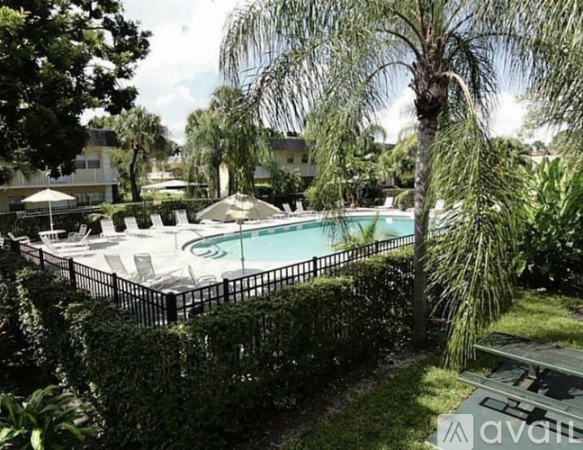 A pool surrounded by greenery and trees.