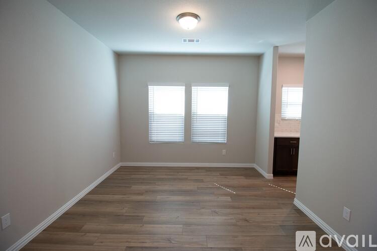 A room with wooden flooring and a window with blinds.