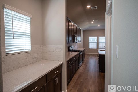 A kitchen with dark wood cabinets and a white countertop.