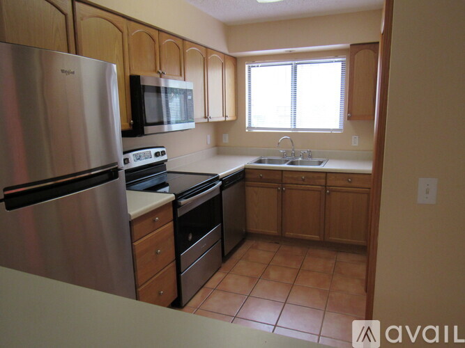 A kitchen with wooden cabinets and a stainless steel refrigerator.