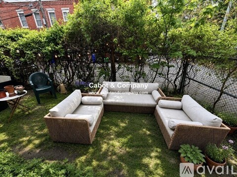 A patio with a white couch and a green chair.