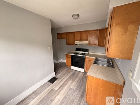 A kitchen with wooden cabinets and a stove top oven.