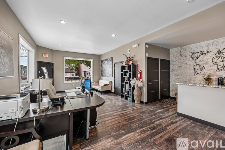 A modern office space with a desk, chairs, and a computer setup.