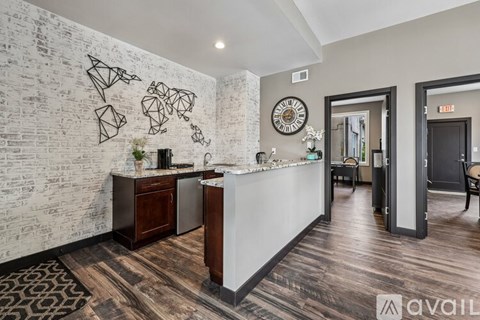 A kitchen area with a white brick wall and a wooden floor.