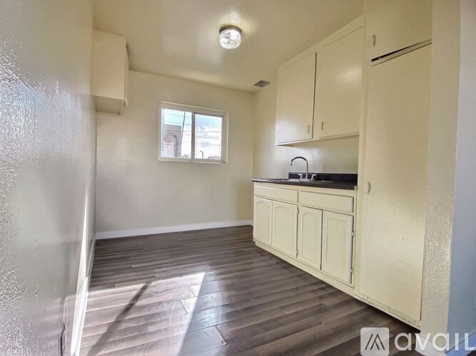 A kitchen with wooden floors and white cabinets.