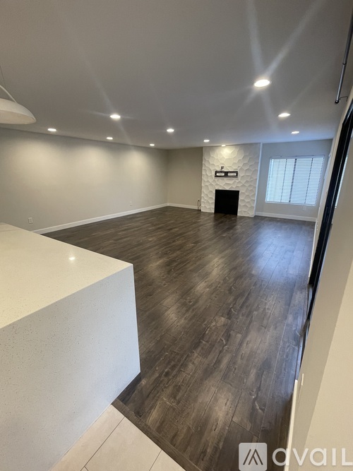 A spacious room with wooden flooring and a white counter.