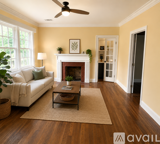 A living room with a white couch, a fireplace, and a ceiling fan.