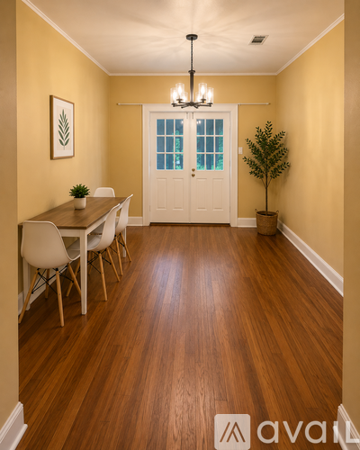 A dining room with a wooden floor and white chairs.