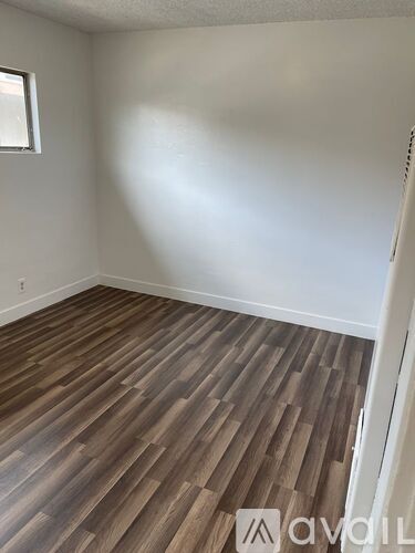 A room with wooden flooring and a window.
