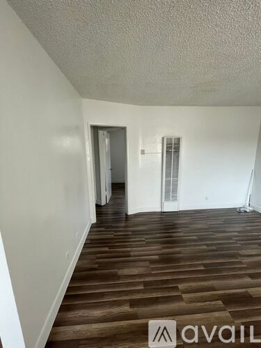 A room with wooden flooring and white walls.