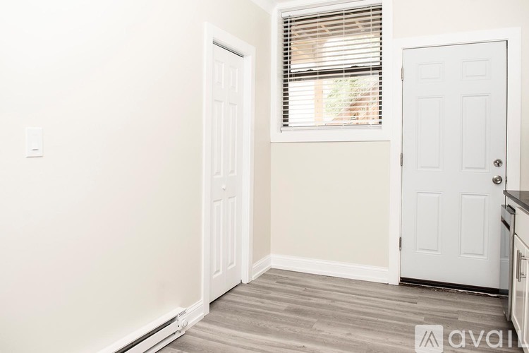 A room with a white door and a window with blinds.