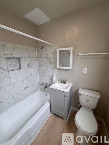 A bathroom with a tub, toilet, and sink.